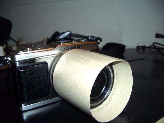 piece of cardboard, wrap around the lens, tape it up.